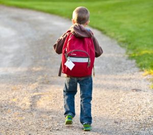 Boy walking to school wearing backpack