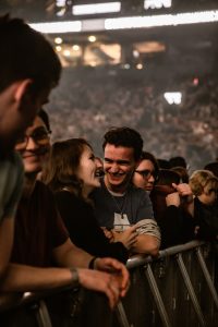 Younger people smiling at a rock concert