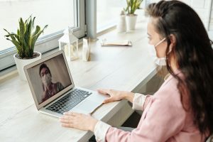Woman working from home wearing a mask during video call