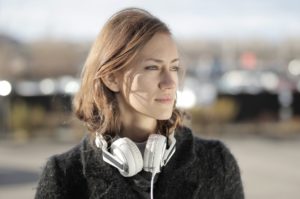 Woman with headphones around her neck outside