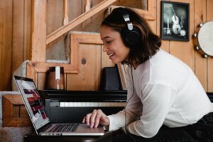 woman wearing headphones and using laptop