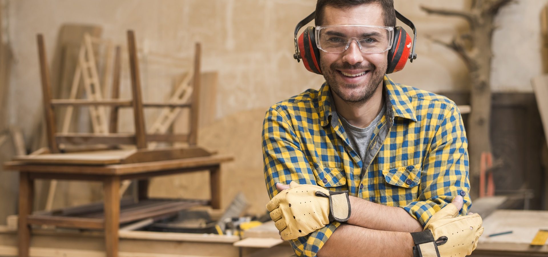 Male carpenter wearing ear protection to prevent hearing loss