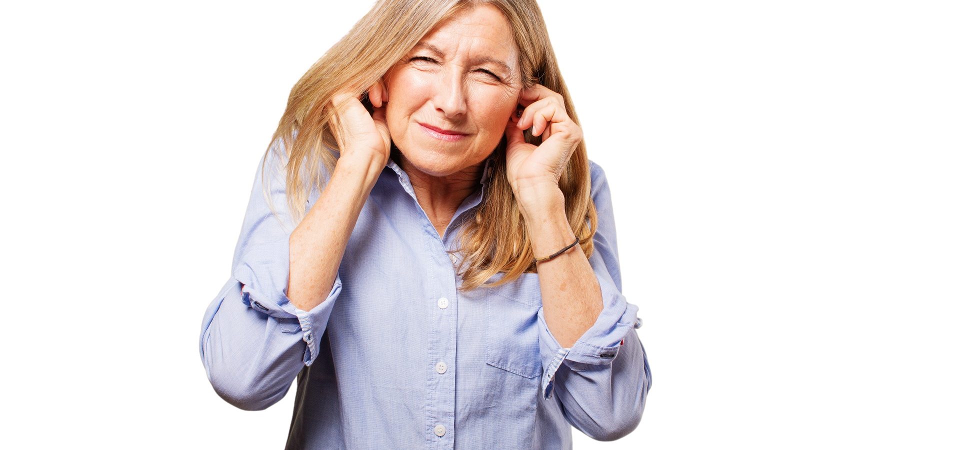 Senior woman covering her ears because of hearing aid feedback noise