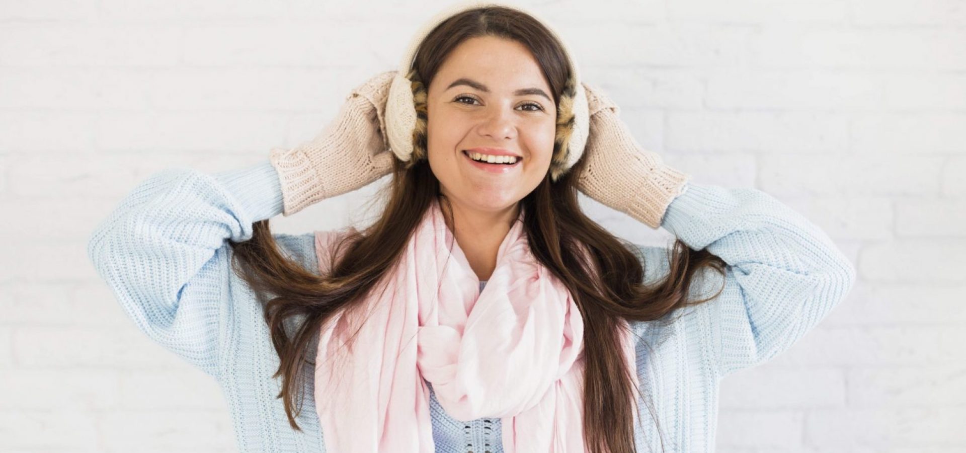 Smiling lady in mittens, earmuffs and scarf Free Photo